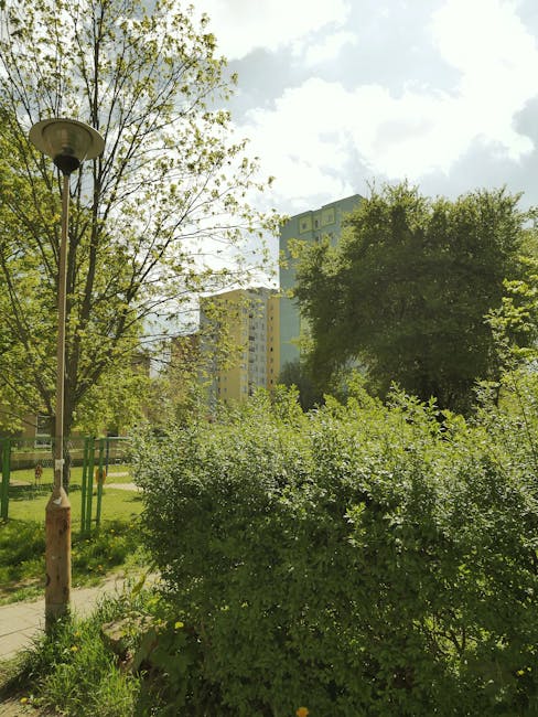A close-up of a red-brick residential building in Walthamstow featuring two windows with closed white blinds; one of the windows is tall and narrow, while the other is broader with a fixed pane at the